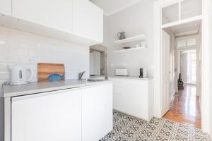 リスボンにあるCharming Apartment Rua da Rosa 33の白いキッチン(白いキャビネット、カウンター付)