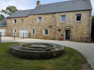 a stone building with a stone circle in front of it at Les Gîtes d'Herquetot -" Les Bruyères" in Vasteville