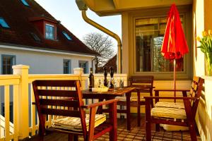 eine Terrasse mit einem Tisch, Stühlen und einem Sonnenschirm in der Unterkunft FeWo an der Ostsee Nr. 4 in Rerik