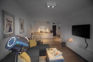 a living room with a gray couch and a kitchen at Apartament Sedina E306 Park Polanki in Kołobrzeg