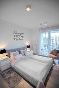 a bedroom with a large bed with pink pillows at Apartament Sedina E306 Park Polanki in Kołobrzeg +23 photos