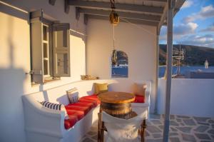 a porch with a bench and a table and a window at Greek Island Charming Studio in Amorgos