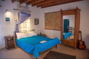 a bedroom with a blue bed and a mirror at Greek Island Charming Studio in Amorgos