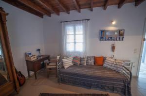 a bedroom with a bed and a desk and a window at Greek Island Charming Studio in Amorgos