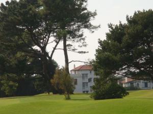 une maison blanche avec des arbres devant elle dans l'établissement Maison Basque, à Biarritz