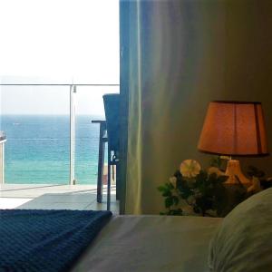 een slaapkamer met een bed en een lamp en de oceaan bij Mirador apart in Calpe