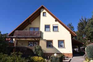 a large white house with a balcony at Ferienwohnung Weiher - Nähe Nürnberg / Messe in Schwanstetten