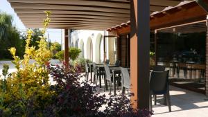 eine Terrasse mit Stühlen, Tischen und einigen Blumen in der Unterkunft Ca' Gemma in Treviso