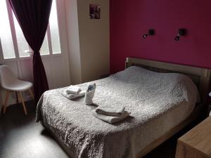 a bedroom with a bed with towels on it at Hotel de la Gare in Dol-de-Bretagne