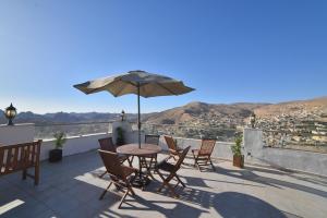 a patio with a table and chairs and an umbrella at Oscar Hotel Petra in Wadi Musa