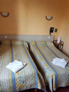 two beds sitting next to each other in a room at Hôtel MAEN-HIR Dol Gare in Dol-de-Bretagne +17 photos
