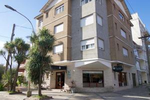 wysoki budynek z palmami przed nim w obiekcie Hotel Santa Eulalia II w mieście Miramar