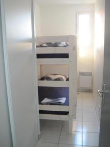 トレイユにあるRésidence Village Marin Catalanの小さな部屋の白い二段ベッド1台分です。