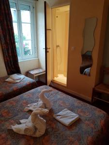 ドル・ド・ブルターニュにあるホテル ドゥ ラ ガールのベッドにタオルを用意しています。