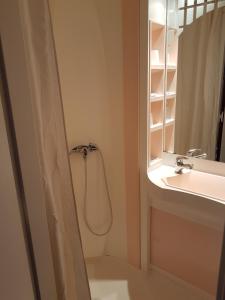 a bathroom with a shower curtain next to a sink at Hotel de la Gare in Dol-de-Bretagne