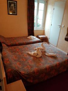 una habitación de hotel con 2 camas con animales de peluche en la cama en Hotel de la Gare en Dol-de-Bretagne