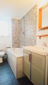 uma casa de banho com uma banheira, um lavatório e um WC. em AVI City Apartments BismarckHouse em Dusseldorf