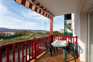 einen Tisch und Stühle auf einem Balkon mit Aussicht in der Unterkunft Luxury apartment with sea view in Hendaye (France) in Hendaye