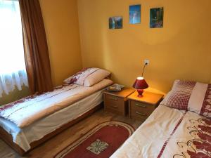 ビエレにあるPokoje Gościnne Pod Magnoliąのベッドルーム1室(ベッド2台、ランプ付きテーブル付)
