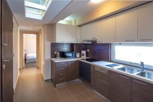 a kitchen with brown cabinets and a sink and a window at Solon - Deluxe City Center Apartment in Athens