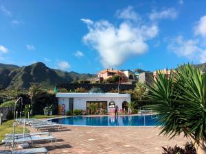 un complejo con piscina y montañas de fondo en Luz Del Mar, en Los Silos