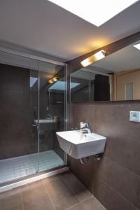 a bathroom with a sink and a shower at Solon - Deluxe City Center Apartment in Athens