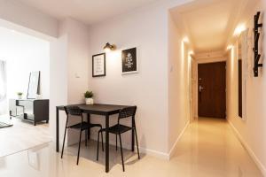 a dining room with a black table and chairs at B&W Ruska Apartment in Wrocław