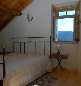 a bedroom with a bed and a large window at Casa da Moreia in Sabugueiro