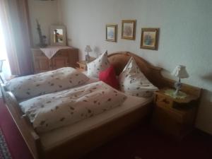 a bedroom with a bed with white sheets and pillows at Haus Pechtl in Sankt Leonhard im Pitztal