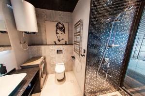 a bathroom with a shower and a toilet and a sink at Porta Batumi Tower in Batumi