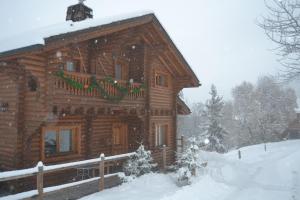 a log cabin in the snow with christmas decorations at Chalet POMMAT in La Tania