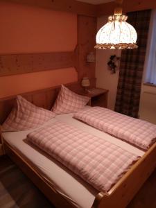 a bedroom with two beds and a chandelier at Haus Pechtl in Sankt Leonhard im Pitztal