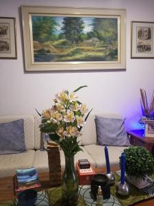 a vase of flowers on a table in a living room at Skylab Guesthouse in Manila