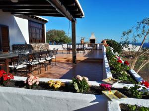 a patio with a table and chairs and flowers at Casa Tara in Mácher