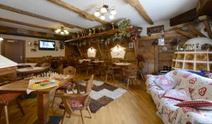 a living room with a couch and tables and chairs at Hotel Presena in Passo del Tonale