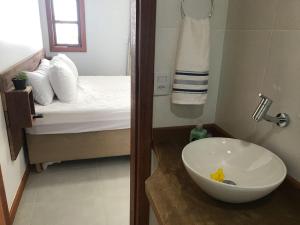 a bathroom with a sink and a room with a bed at Reserva do Ule in Ponta da Fruta