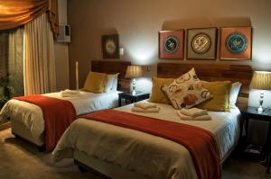 a hotel room with two beds and two lamps at Rest-a-While Guest House - Pretoria in Pretoria +31 photos