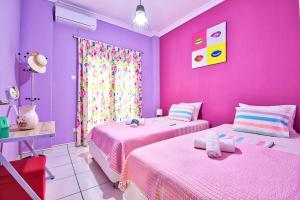 2 camas en una habitación con paredes rosas y moradas en Lofos Apartment, en Atenas