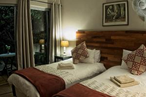 a bedroom with two beds with towels on them at Rest-a-While Guest House - Pretoria in Pretoria