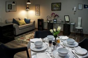 a living room with a table with plates and bowls at Rest-a-While Guest House - Pretoria in Pretoria