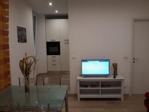 a living room with a table and a television at Alysia Apartment in Genoa