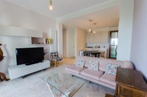 a living room with a pink couch and a tv at Luxury Apartment with bay view in Sanremo