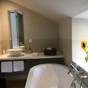 ein Badezimmer mit einer Badewanne, einem Waschbecken und einem Spiegel in der Unterkunft B&B La Gotale in Manhay