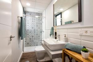 ein Badezimmer mit einem Waschbecken, einem WC und einem Spiegel in der Unterkunft Chezmoihomes Sweet & Trendy nest in Granada Center for 6 in Granada