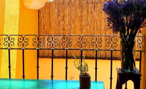 a table with two vases of flowers on top of a fence at Casa Gecko in Oaxaca City
