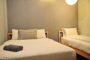 two beds sitting next to each other in a room at GRAYHAUS SOHO Ipoh in Ipoh