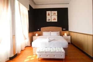 a bedroom with a large white bed and two windows at Tahrir Plaza Suites - Museum View in Cairo