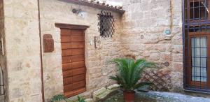 a stone building with a wooden door and a plant at Palazzo Urbani in Orvieto
