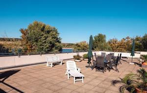 een patio met stoelen, tafels en parasols bij Sonnenstube mit Pool und Sauna in Möhnesee