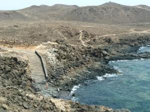 un escalier sur une colline rocheuse à côté de l'eau dans l'établissement Casa Daniel, à Costa Teguise